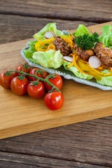 Vegetable salad and cherry tomato on wooden board 