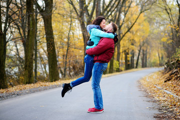 Portrait of young loving couple kissing in autumn park