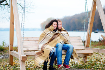 Amorous couple on romantic date on swings outdoor