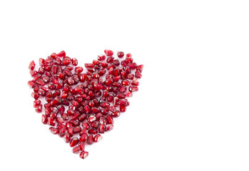 Fototapeta na wymiar Juicy sweet delicious pomegranate seeds heart isolated on white background, I love you concept, valentine's day