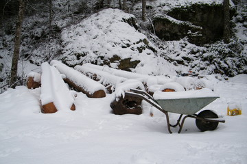 Firewood Logs in the snow with Wheelbarrow