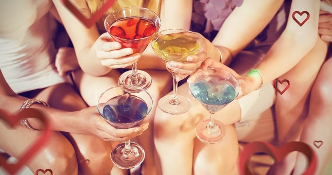 Composite image of girls with cocktails toasting