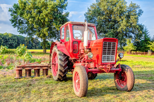 Landwirtschaftliches Fahrzeug - alter Traktor auf einem Feld stehend