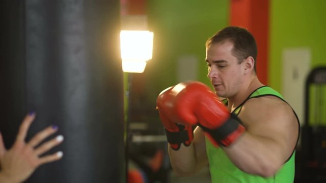 Young boxer man practicing on a punching bag