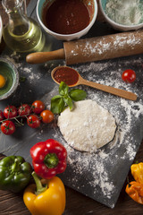 Preparing pizza with dough and tomato sauce