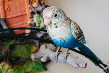 blue mobile plastic bird stand on the fake wood