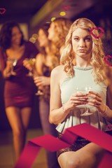Composite image of blonde woman drinking cocktail
