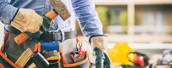 Worker with a tool belt and a hammer