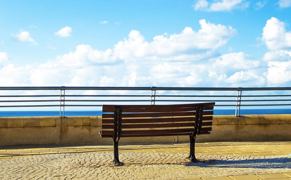 Wooden bench in the park on a background of sea