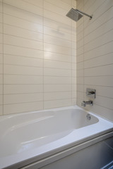 White bathtub in a tiled bathroom. Interior design.