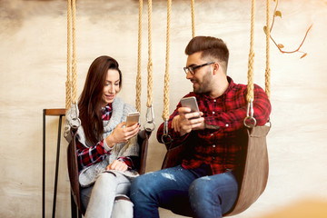 Couple enjoying talking and using their phones.