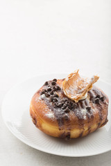 Cannoli doughnut/donut on a white plate. White background. Copy space. 
