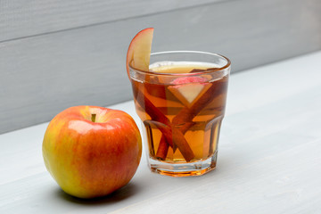 glass with juice, pieces of apple, cinnamon, apple
