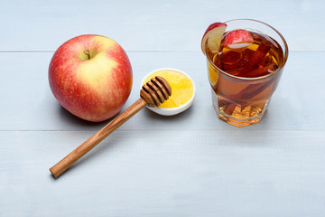 glass with juice, pieces of apple, cinnamon, honey, honey stick