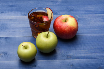 glass with juice, pieces of apple, cinnamon, apples