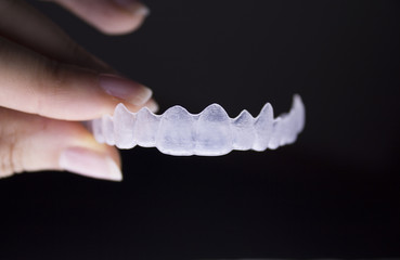Woman holding invisible dental orthodontics