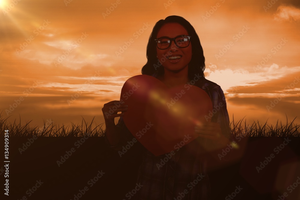 Wall mural Composite image of asian woman holding paper heart