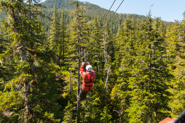 Man zip-lining across tree tops