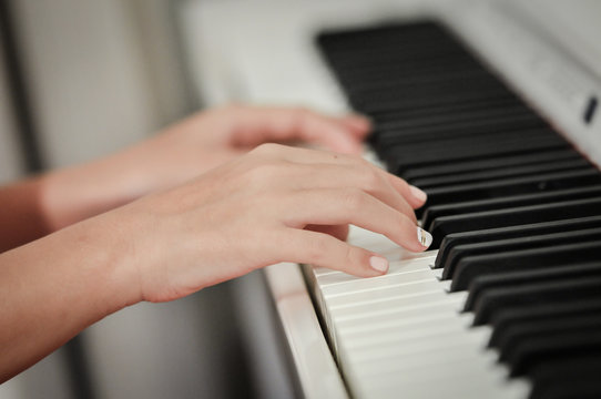 Hand playing on digital piano. Close-up. Small depth of field.