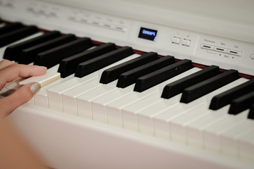 Hand playing on digital piano. Close-up. Small depth of field.