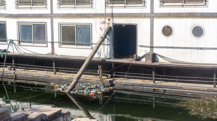 Old rusty cruise ship with trash around it