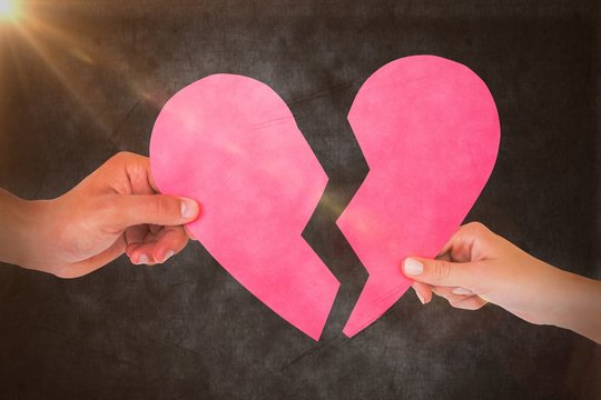 Composite image of couple holding two halves of broken heart