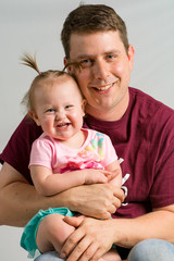 Happy father and daughter together in front of a light grey background