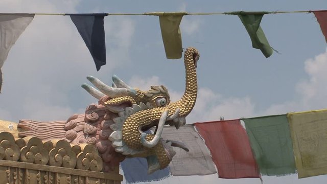 Close up from a dragonhead with prayer flags around Boudha stupa in Kathmandu