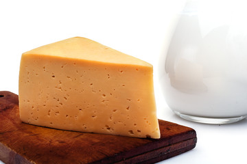 cheese on a kitchen board, a jug of milk isolated