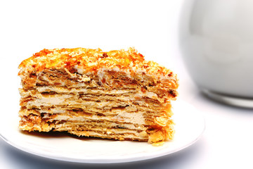 flaky pastry with cream on a plate next to a jug with milk. isolated