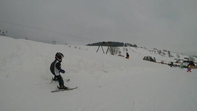 Skiing lessons. Ski school.
Little boy learning to ski. Father teaches son to ski.