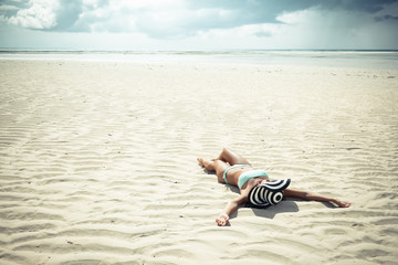 a young woman lying on the sand