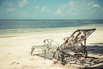 an old rusty deck chairs on the beach