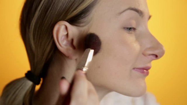 Female beauty, beautiful mid adult woman putting on fard and make-up