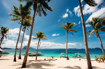 Tropical beach with palm trees, pilippine boats. Paradise. Philippines.