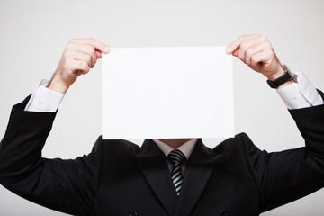 Man in business suit holding white paper in hands. Free space for your text