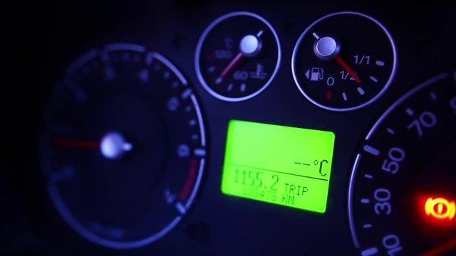 Color footage with lights coming on and off on a car's dashboard.