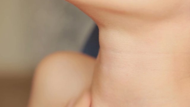 throat close up. Little boy with a sore throat. Holding his neck