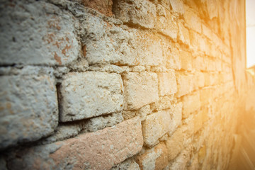 Old red brick wall in a background with sunlight. Selective focus