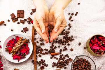 Spa composition of female hands, coffee beans and petals
