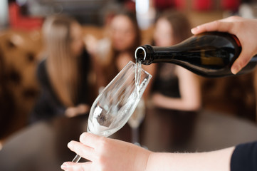 Man pours champagne in wineglasses