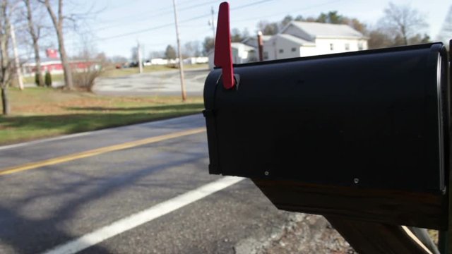 Car passes mailbox in summer suburban road