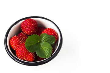Fresh strawberry in a mug on white background