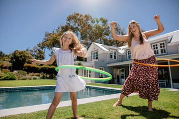 Happy mother and daughter twirling hula hoops © Jacob Lund