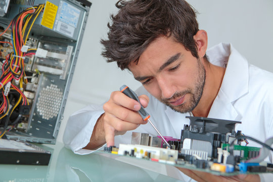 Computer repairman using screwdriver