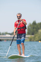 man enjoying a ride on the lake with paddleboard