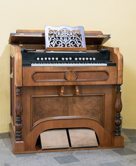 Fototapeta na wymiar Old decorative piano stands beside the wall