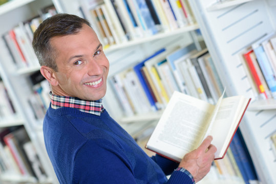 Man in library, turning and smiling