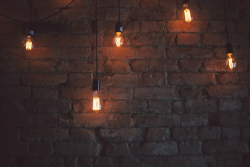 Switched on bulbs with brick wall background.