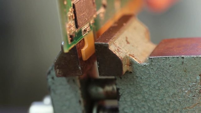 Put electronic circuit in the vise for dismantling
